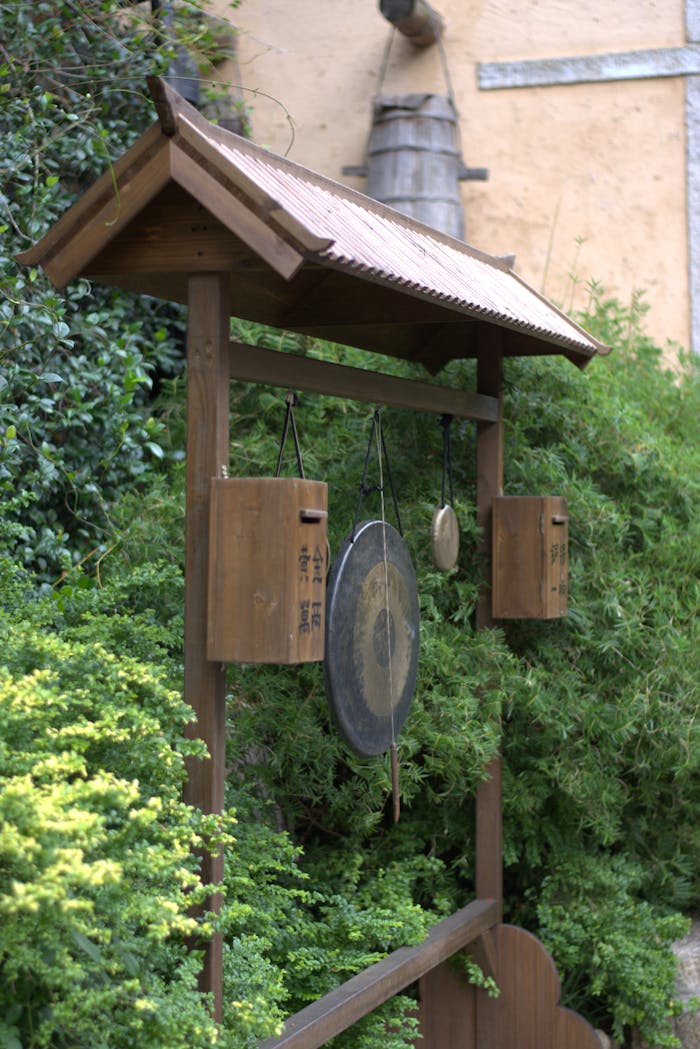 Wooden gong structure in a tranquil Japanese garden setting.